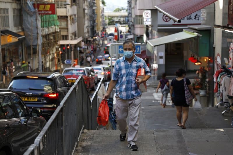 ▲新冠肺炎疫情近期在各地有加溫的跡象。（圖為香港街頭／美聯社／達志影像）