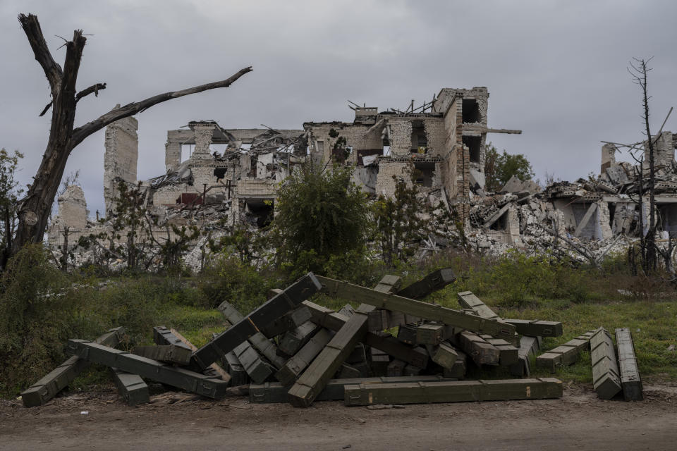 Cajas de municiones están afuera de una escuela destruida en una aldea recientemente liberada en las afueras de Jersón, en el sur de Ucrania, el miércoles 16 de noviembre de 2022. (AP Foto/Bernat Armangue, Archivo)