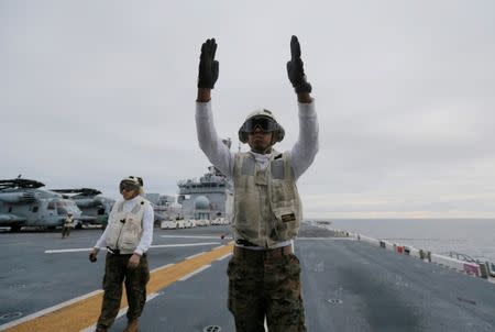 A crewman aboard the USS Bonhomme Richard amphibious assault ship guides the press off a U.S. Marines MV-22B Osprey Aircraft before a ceremony marking the start of Talisman Saber 2017, a biennial joint military exercise between the United States and Australia off the coast of Sydney, Australia, June 29, 2017. REUTERS/Jason Reed