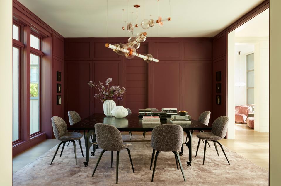 The dining room walls weren’t initially painted purple, but something inspired Lau to take the bold plunge. “Edel knew what she was talking about,” says Lau, who adds, “I’m excited to start entertaining inside again.” The Kelly Lamb God’s Eye Table is surrounded by Gubi Beetle chairs upholstered in Knoll fabric and Holly Hunt leather trim detail. Hanging from the ceiling is a Gabriel Scott Luna Three Tier Chandelier that shines against the aubergine wall color, which is Wine Stain by Dunn Edwards.