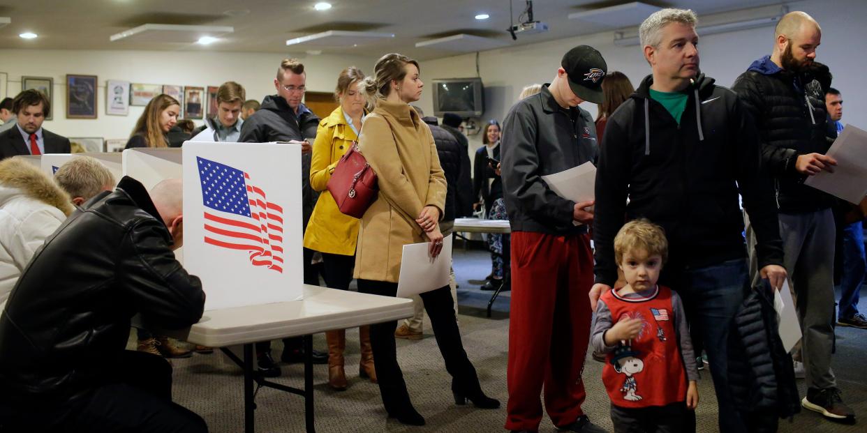 Voters fill out their election ballots as others wait for an open space at a booth on November 6, 2018 in Des Moines, Iowa.