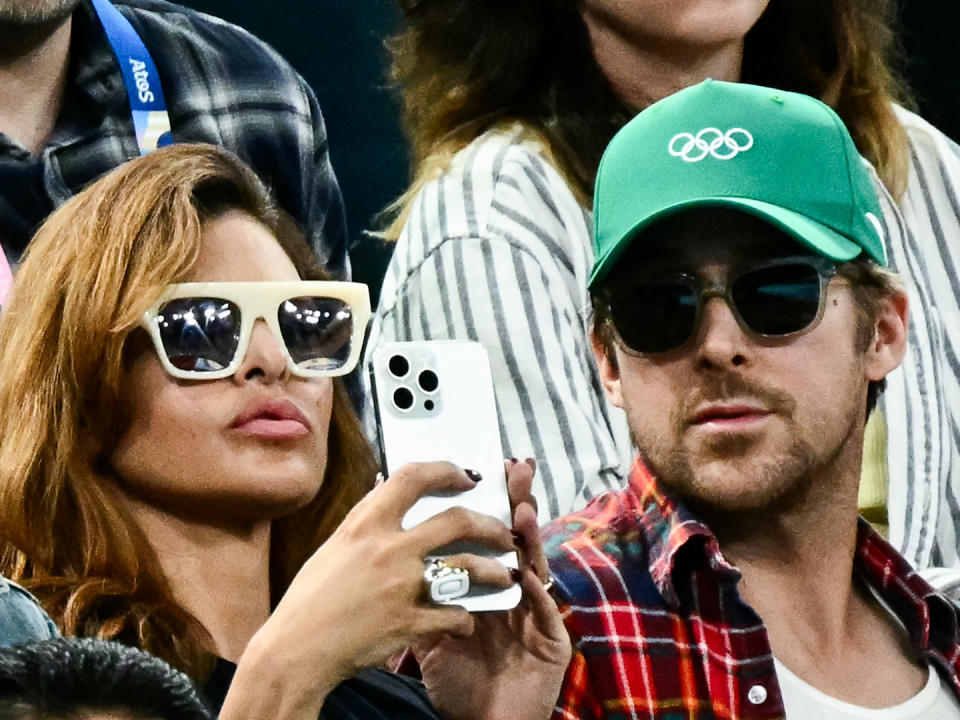 US actress Eva Mendes (left) and her partner, Canadian actor Ryan Gosling (right), attend the women's uneven bars final of artistic gymnastics during the Paris 2024 Olympic Games at the Bercy Arena in Paris on August 4, 2024. (Photo by Loic VENANCE / AFP)