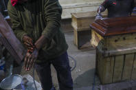 Haitian migrant and coffin factory worker Francois Joseph cleans his hands after day of work at the Bergut Funeral Services factory in Santiago, Chile, Thursday, June 18, 2020. DCoffin production has had to increase up to 120%, according to Nicolas Bergerie, owner of the factory. His more basic coffin model is called the COVID model and is made to cope with the increase of deaths during the coronavirus pandemic. (AP Photo/Esteban Felix)