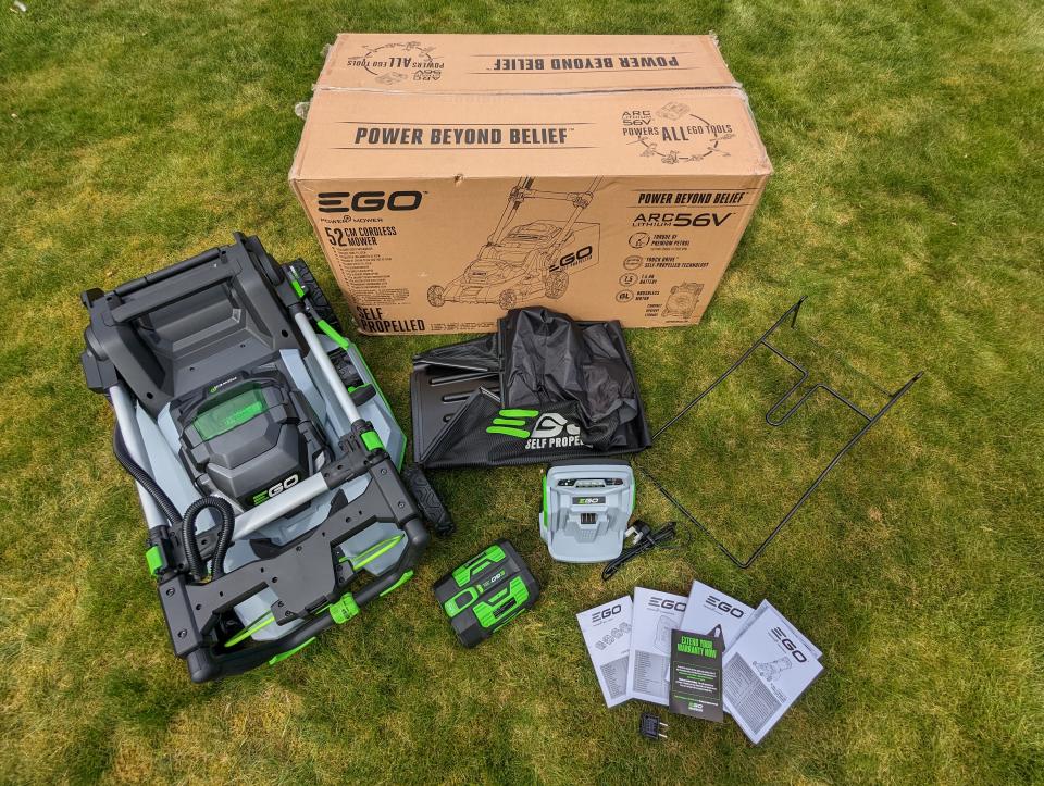 Unboxing the EGO LM2130E mower, displaying the box, mower, grass collector, instructions and battery