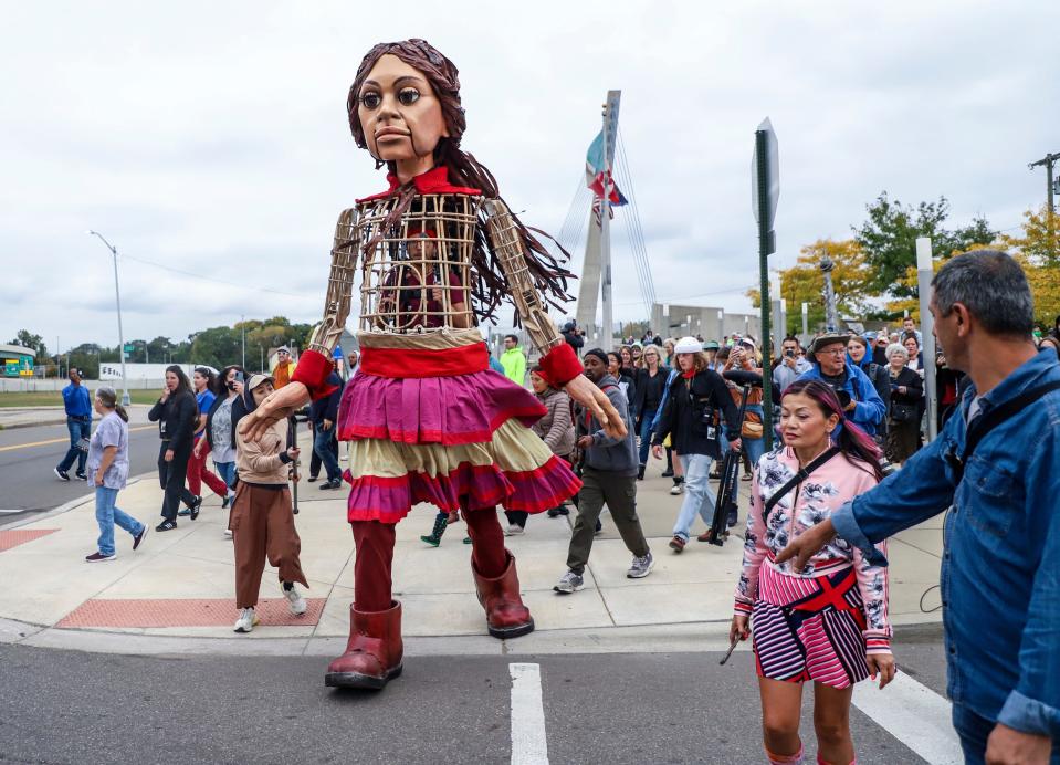 Little Amal, a 12-foot-tall puppet of a 10-year-old Syrian refugee girl, traveled to Detroit as a symbol of displaced people across the globe and walked across the Bagley Pedestrian Bridge, stopping at the Southwest Detroit Immigrant and Refugee Center and Matrix Theatre Company in southwest Detroit on Wednesday, Sept. 27, 2023.