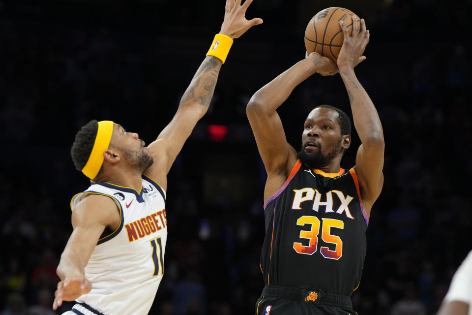 Phoenix Suns forward Kevin Durant (35) shoots over Denver Nuggets forward Bruce Brown during the first half of an NBA basketball game Thursday, April 6, 2023, in Phoenix. (AP Photo/Rick Scuteri)