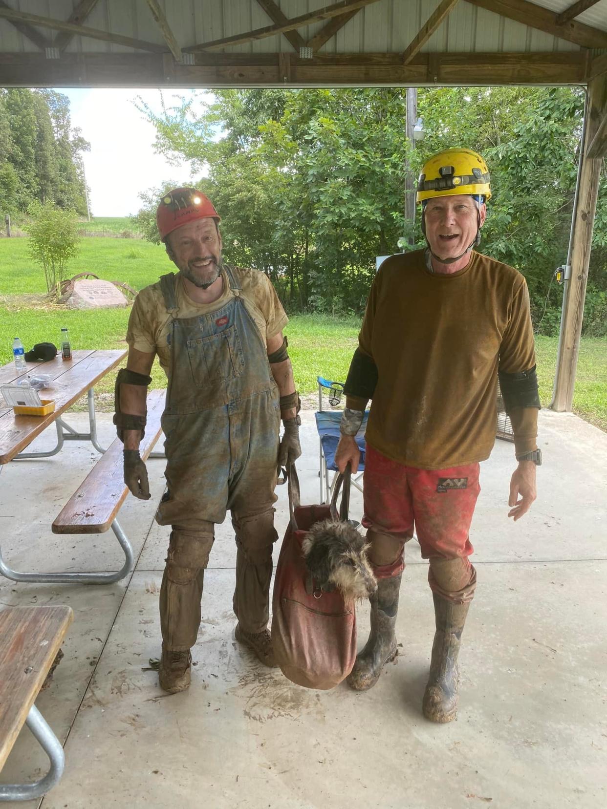 Recreational cavers Gerry Keene, left, and Rick Haley, right, carry Abby, a 13-year-old dog who reportedly went missing on June 9, after staging a rescue operation to help save the dog on Aug. 6, Haley said.