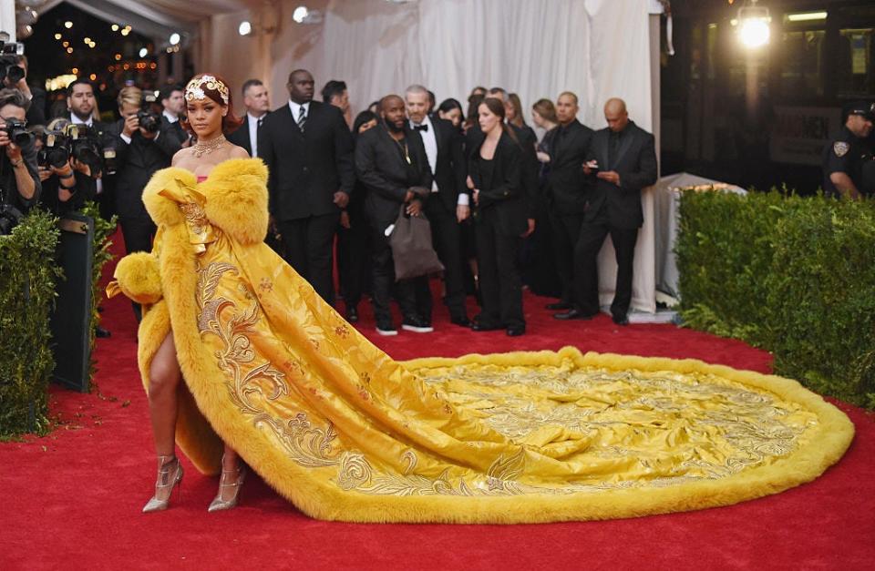Rihanna's 2015 Met Gala look is probably her most iconic: a dramatic yellow dress with a large train with fur trim and a gold headpiece.