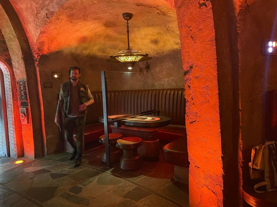 worker standing in front of booth at oga's cantina