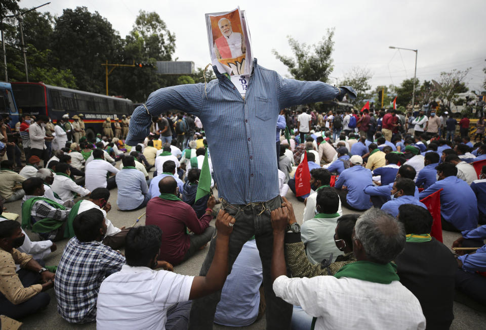 Protesting farmers hold an effigy of Indian prime minister Narendra Modi during a demonstration against new farming laws in Bangalore, India, on Dec. 9, 2020. Modi Friday held virtual talks with farmers from six states and asked them to explain how the government’s agricultural policies have benefited them, a month after facing massive farmer protests that have rattled his administration. (AP Photo/Aijaz Rahi)