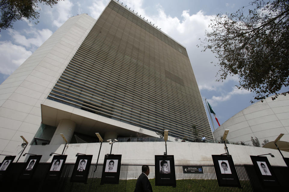 Photographs of the teachers college students who disappeared on Sept. 26, 2014 hang on the fence surrounding the senate building in Mexico City, Wednesday, Sept. 26, 2018. President-elect Andres Manuel Lopez Obrador said Wednesday his administration will accept a truth commission to investigate the case of the 43 missing students, drawing rare praise and expressions of hope from the long-suffering parents of the victims.(AP Photo/Rebecca Blackwell)