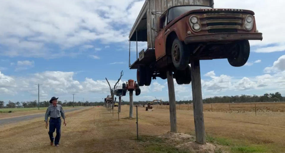 Jim Sauer standing next to his Row of Machinery tourist attraction on his rural property outside of Bundaberg. 