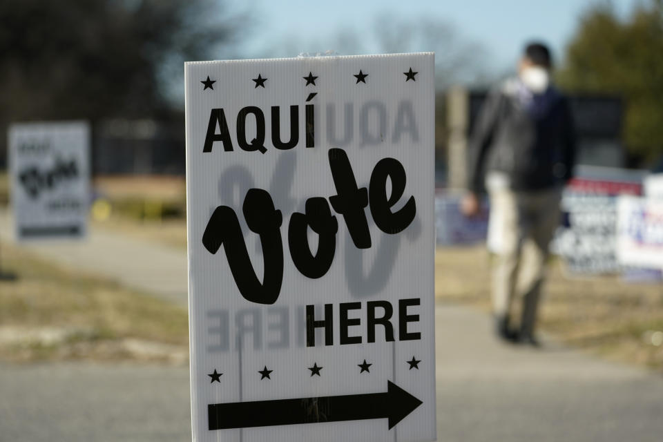 A man passes an early voting poll site, Monday, Feb. 14, 2022, in San Antonio. Early voting in Texas began Monday. (AP Photo/Eric Gay)