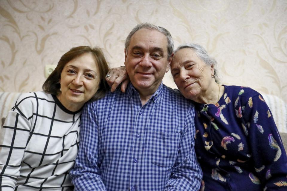 Adil Sharifov poses for a photo with his sister Kamala Sharifova and his mother Adila Ahmadova at home in Baku, Azerbaijan, Friday, Nov. 20, 2020. Adil Sharifov, 62, who left his hometown in 1992 during the first war and lives in Azerbaijan's capital, Baku, knows he will find similar devastation if he returns to the city of Jabrayil, which he longs to do. (AP Photo/Aziz Karimov)