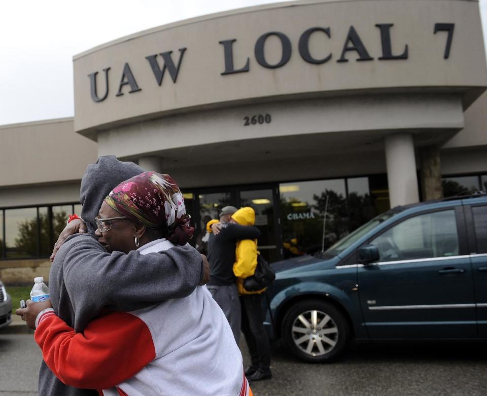 Employees hug in front of the UAW Local 7 hall across the street from Chrysler Jefferson North Assembly plant in Detroit on Thursday, Sept. 20, 2012 after a factory employee fatally stabbed his co-worker at Chrysler Group LLC's Jefferson North Assembly Plant. Detroit police Inspector Dwane Blackmon says the suspect fled the Jefferson North plant Thursday morning and shot himself to death at nearby Belle Isle Park. (AP Photo/Detroit News, David Coates) DETROIT FREE PRESS OUT; HUFFINGTON POST OUT. MANDATORY CREDIT