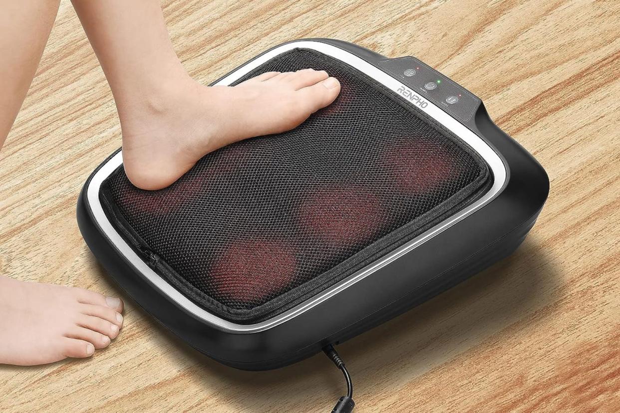 someone stepping on the heated foot massager from Amazon 