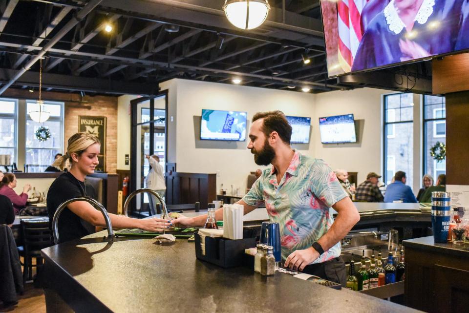 Kevin Gawronski, Asst. GM at The Old Bag of Nails hands a drink to a server Monday, Dec. 5, 2022.