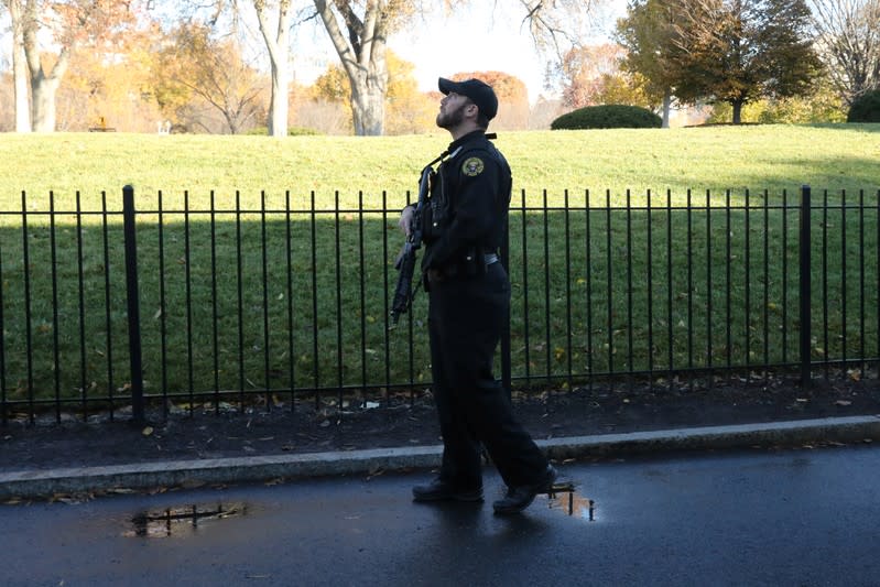 A Secret Service agent scans the skies over the White House during a lockdown because of reporters of a stray airplane over Washington