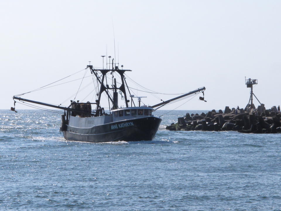 In this Sept. 11, 2019 photo, the commercial fishing boat Ann Kathryn sails into the Manasquan Inlet in Manasquan, N.J. Although they support effortsto fight climate change and its impact on the world's oceans, the fishing industry fears it could be harmed by one of the promising solutions: the offshore wind energy industry. At a Congressional subcommittee hearing Monday Sept. 16, 2019 in New Jersey, fishermen asked for a seat at the table when important wind energy decisions are made, including where projects are located. (AP Photo/Wayne Parry)