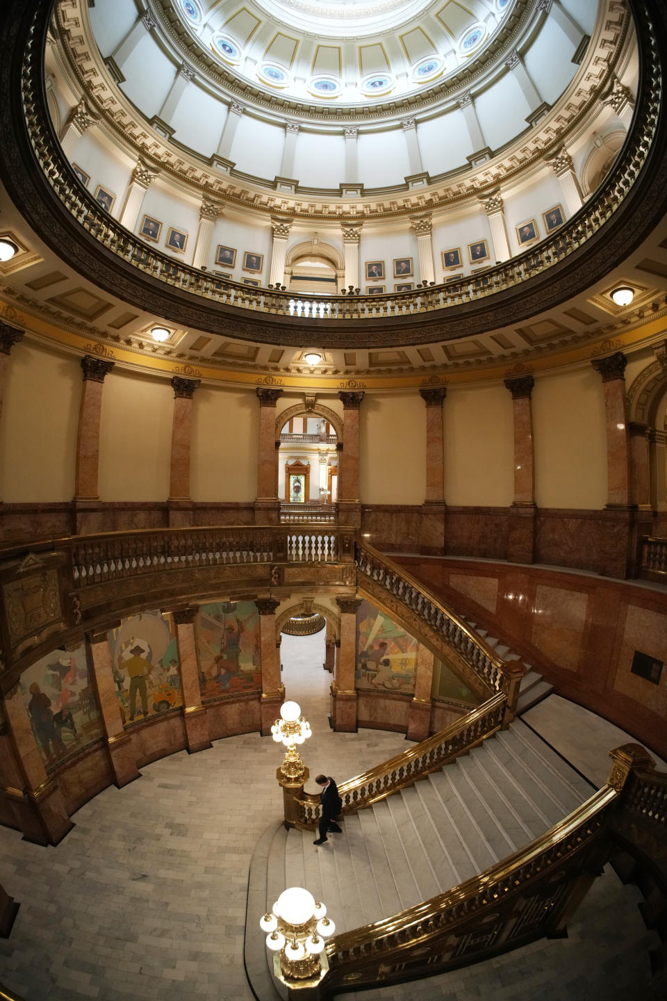 A person walks the stairs in the rotunda of the State Capitol, Monday, May 8, 2023, in Denver. (AP Photo/David Zalubowski)