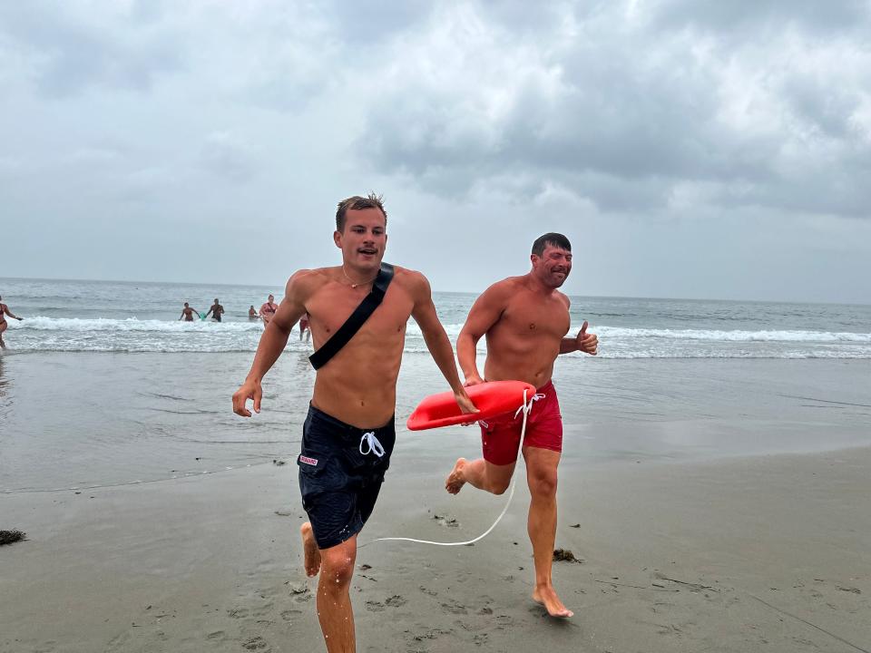 Hampton Beach lifeguards running to shore during one of several demonstrations at Thursday's Water Safety Day.