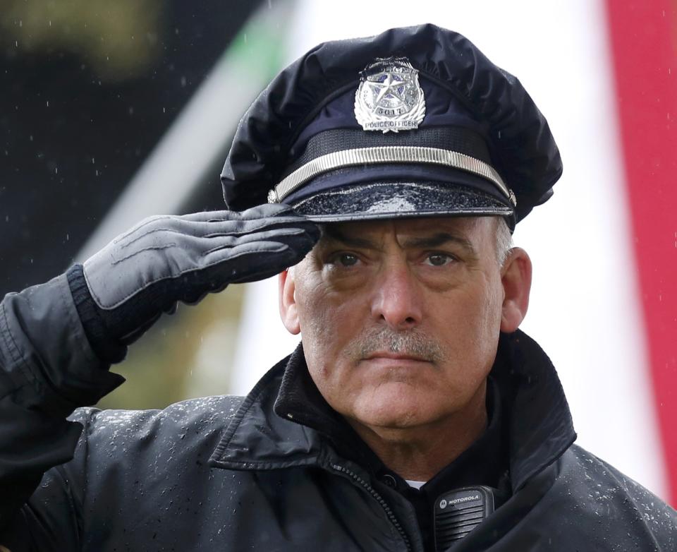 A Dallas police officer salutes in Dealey Plaza during ceremonies marking the 50th anniversary of JFK's assassination in Dallas