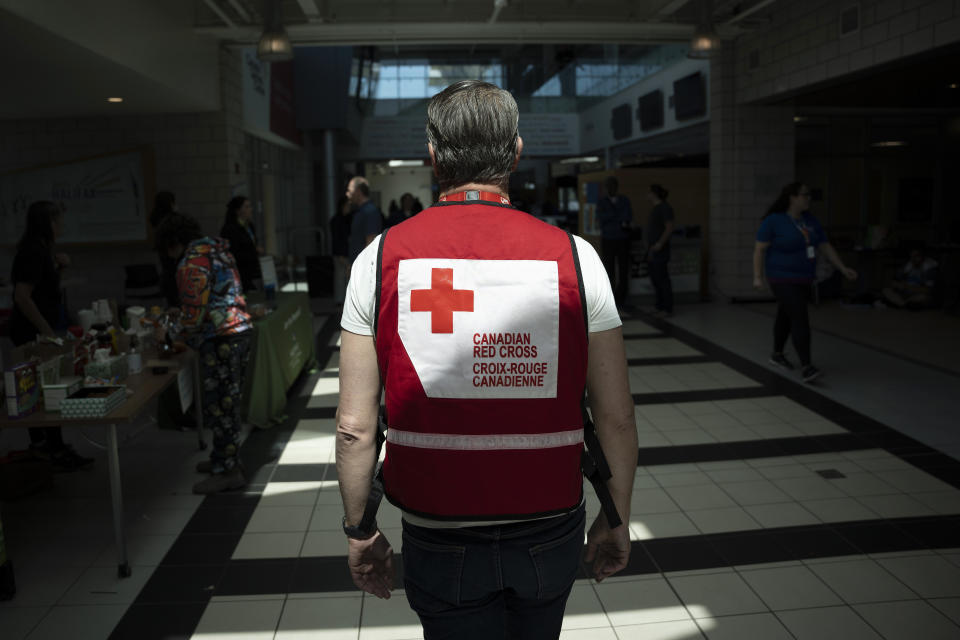A representative from the Canadian Red Cross works at an evacuation centre where food and shelter is being provided for those forced from their homes due to the wildfire burning in suburban Halifax, Nova Scotia, on Tuesday, May 30, 2023. (Darren Calabrese/The Canadian Press via AP)