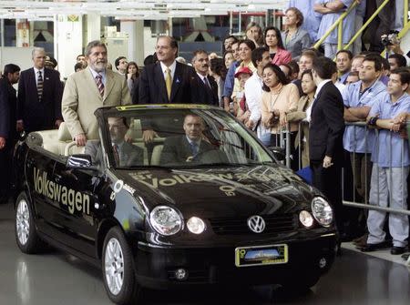 Brazil's then-President Luiz Inacio Lula da Silva (L, standing in car) rides with Sao Paulo State Governor Geraldo Alckmin in a Volkswagen Polo inside an assembly plant, during a visit to celebrate the company's 50th anniversary of production in Brazil, in Sao Bernardo do Campo, in this March 24, 2003 file photo. REUTERS/Jose Patricios/Files