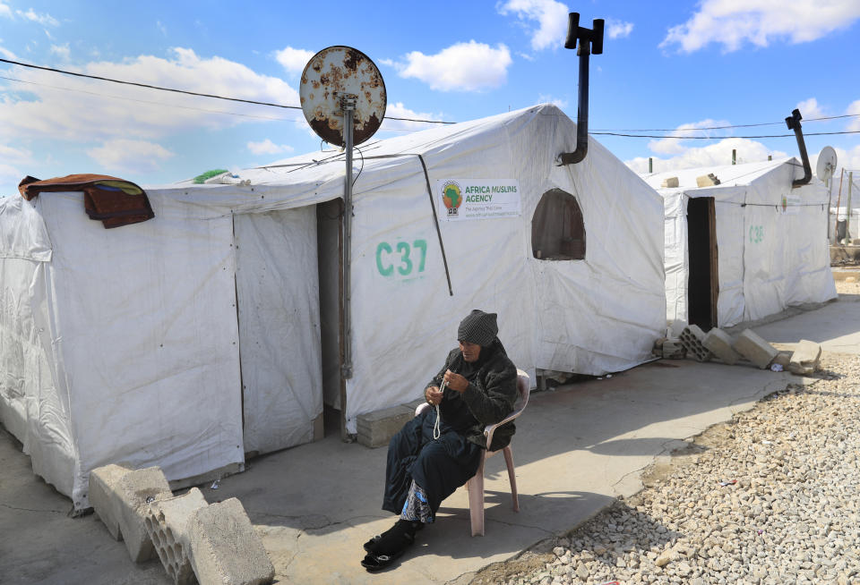 A Syrian displaced woman sits outside her tent, as she enjoying the sunny weather at a refugee camp, in Bar Elias, in eastern Lebanon's Bekaa valley, Friday, March 5, 2021. Syria has been mired in civil war since 2011, after Syrians rose up against President Bashar Assad amid a wave of Arab Spring uprisings. Nearly ten years later, millions of displaced Syrians unlikely to return in the foreseeable future, even as they face deteriorating living conditions abroad. The Syrian conflict has resulted in the largest displacement crisis since World War II. (AP Photo/Hussein Malla)