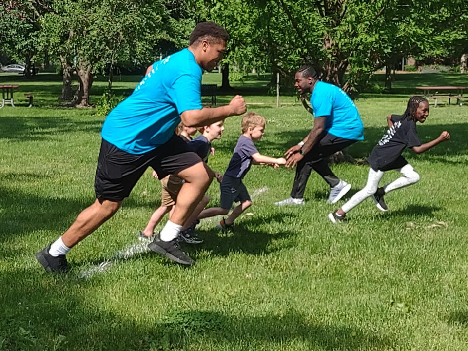 Kansas football players Earl Bostick Jr. and Jalon Daniels engage with kids during the 5K Home Run supporting Family Promise of Lawrence.