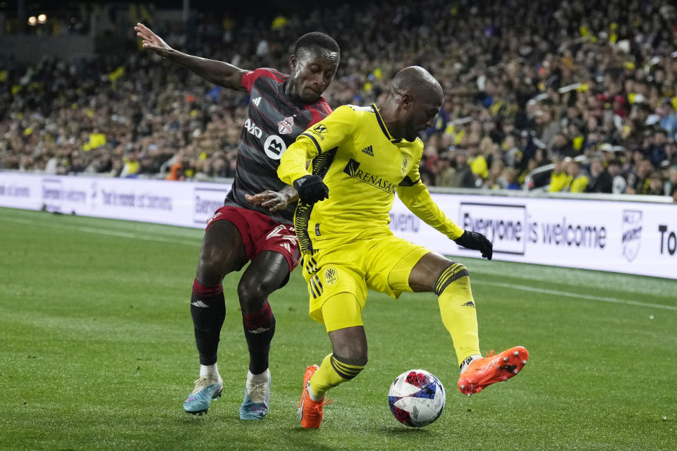 Toronto FC's Richie Laryea (22) and Nashville SC's Fafà Picault, right, vie for the ball during the second half of an MLS soccer match Saturday, April 8, 2023, in Nashville, Tenn. (AP Photo/Mark Humphrey)