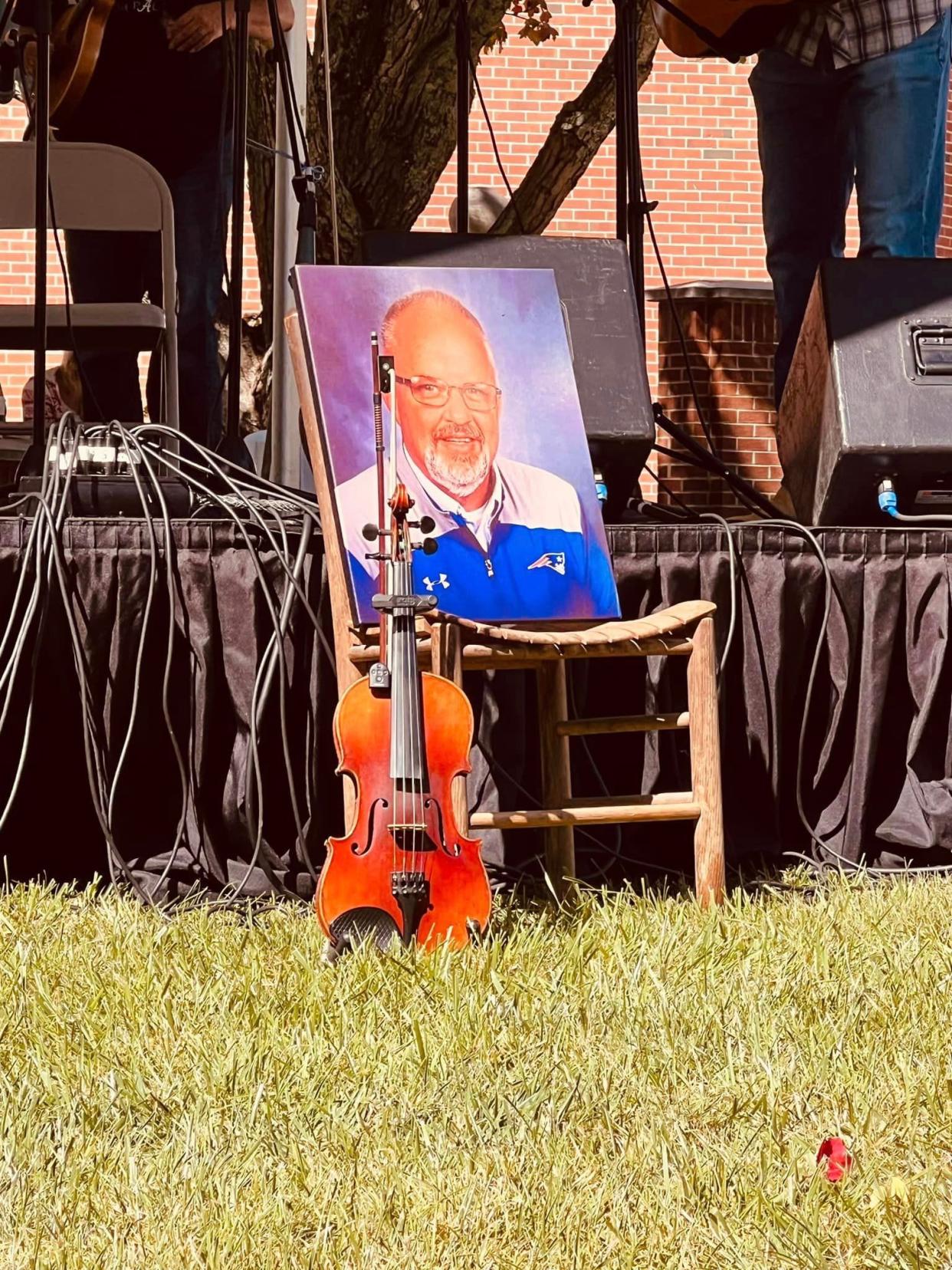 A photo of David Robinson sits on the chair on which he used to sit while playing music at "Sunday School," a jam session at Doug Phillips' cabin featuring local musicians and bandmates of Robinson's "Southern Heritage" group, on Sept. 23 at the Lunsford Festival.