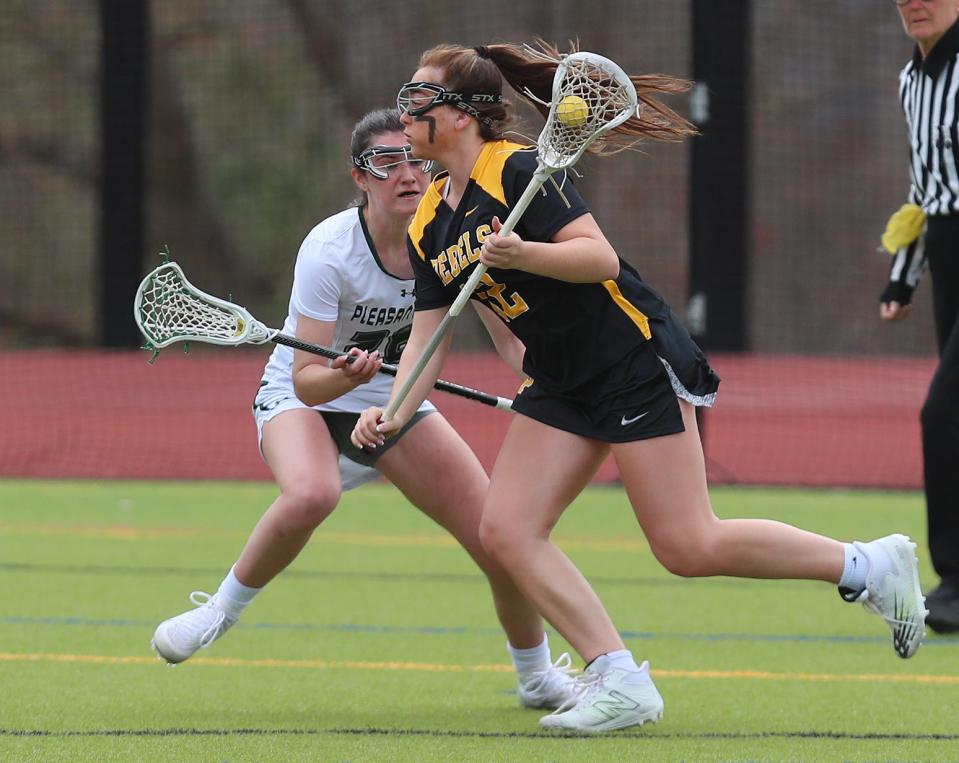 Lakeland/Panas' Madalena DiMirco (12) tries to drive to the goal in front of Pleasantville's Rowan Capko (28) during girls lacrosse action at Pleasantville High School April 7, 2023. Lakeland/Panas won the game 15-12.  