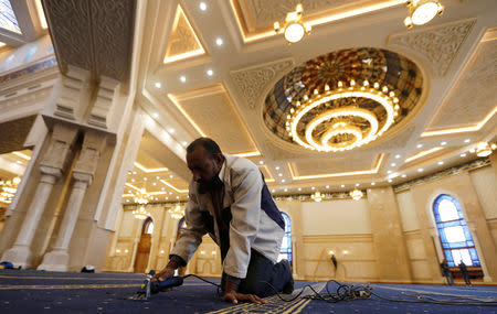 A worker adjusts the carpet inside the newly-constructed mosque Al-Fattah Al-Alim at the New Administrative Capital (NAC), east of Cairo, Egypt, January 3, 2019. REUTERS/Amr Abdallah Dalsh