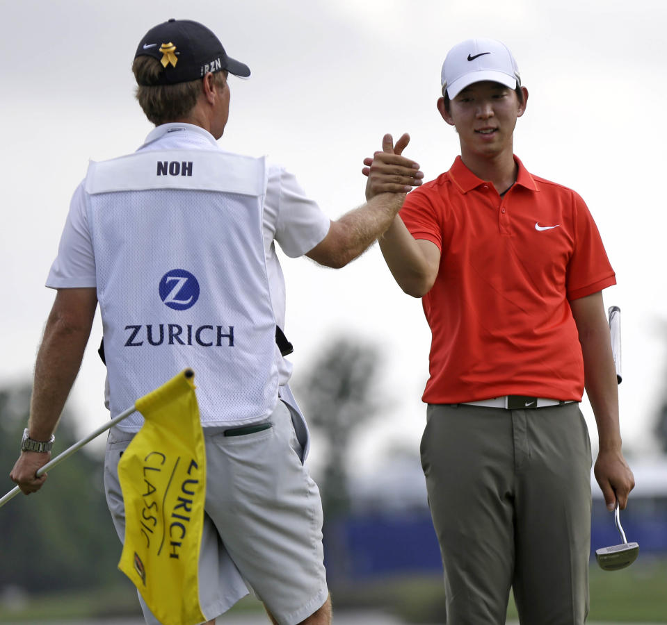 Noh Seung-yul, right, of South Korea, is congratulated by caddy Scott Sajtinac on the 18th green after winning the Zurich Classic golf tournament at TPC Louisiana in Avondale, La., Sunday, April 27, 2014. (AP Photo/Bill Haber)