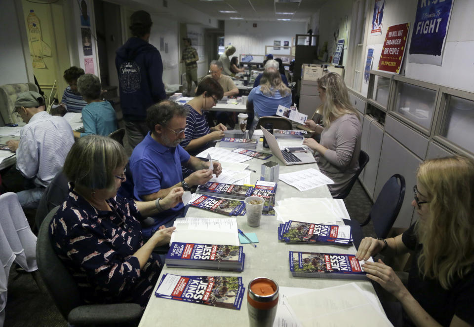 Volunteers put address stickers with voting location on a door hangers promoting Jess King, a Democratic candidate in Pennsylvania's 11th Congressional District, Friday Nov. 2, 2018, in Lancaster, Pa. Voters in Pennsylvania's rolling dairy farms and Amish countryside had rarely, if ever, seen a Democrat mount a competitive campaign for Congress, until now. From all appearances, first-time candidate Jess King is giving freshman Republican U.S. Rep. Lloyd Smucker a fight to the finish in Tuesday's election in this conservative district. (AP Photo/Jacqueline Larma)