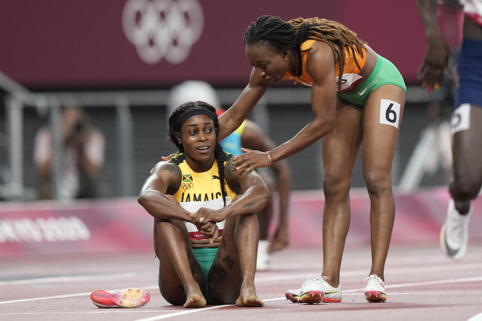 Elaine Thompson-Herah, of Jamaica, is congratulated by Marie-Josee Ta Lou, of Ivory Coast, after winning the final of the women's 200-meters at the 2020 Summer Olympics, Tuesday, Aug. 3, 2021, in Tokyo. (AP Photo/David Goldman)