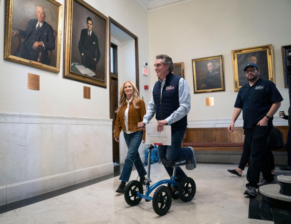 Oct 12, 2023; Concord, NH, USA; Republican presidential candidate Doug Burgum along with his wife Kathryn Burgum arrive to file paperwork at the New Hampshire State House and the New Hampshire Secretary of State office to get on the New Hampshire 2024 Republican presidential primary ballot.