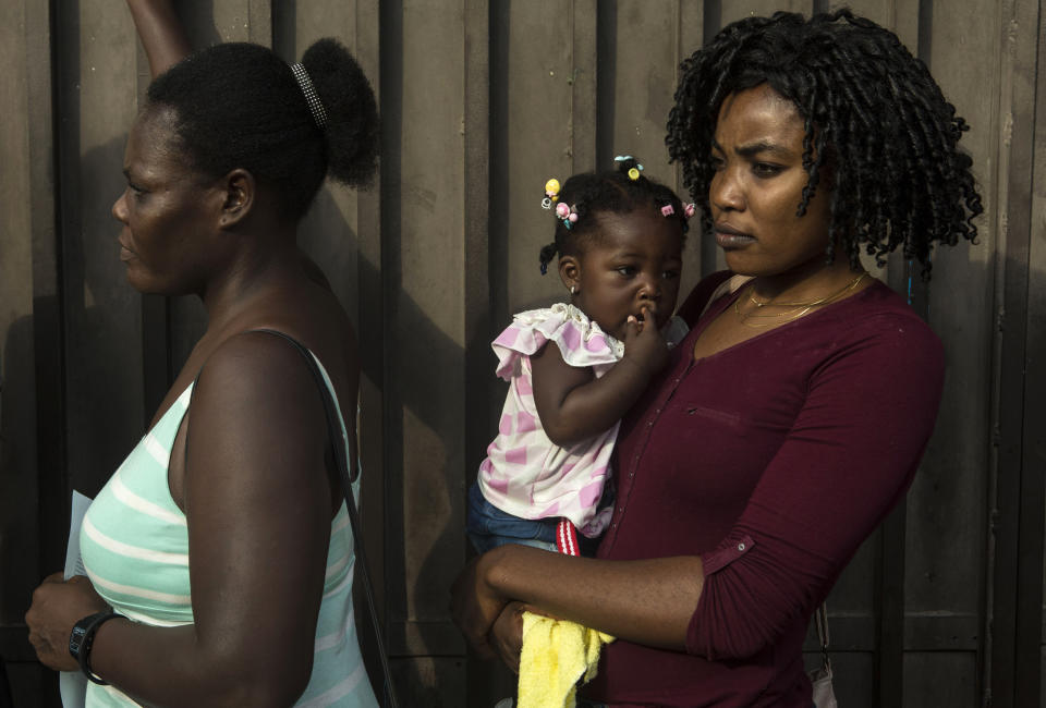 Haitian migrants wait in line outside the Mexican Commission for Migrant Assistance office to get the documents needed that allows them to stay in Mexico, in Tapachula, Thursday, June 20, 2019. The flow of migrants into southern Mexico has seemed to slow in recent days as more soldiers, marines, federal police, many as part of Mexico's newly formed National Guard, deploy to the border under a tougher new policy adopted at a time of increased pressure from the Trump administration. (AP Photo/Oliver de Ros)