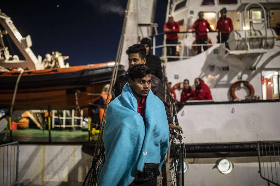 FILE - In this Jan. 15, 2020 file photo, men from Bangladesh disembark from the Open Arms rescue vessel at the port of Messina after being rescued on Friday off the Libyan coast, in Sicily, Italy. The European Union announced Tuesday, March 31, 2020 the launch of a new naval mission in the Mediterranean Sea aimed at enforcing the U.N arms embargo on Libya, after Italy blocked a previous operation claiming that the warships attracted migrants. (AP Photo/Santi Palacios, File)