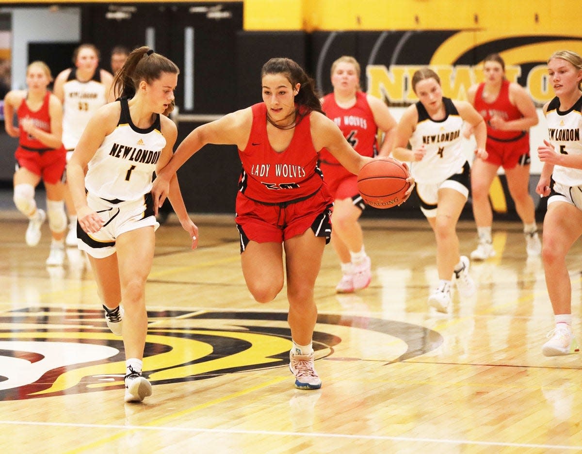 Winfield-Mt. Union’s Melina Oepping takes the ball up the court chased by New London’s Natalie Burden in their season opening game Friday night at New London.