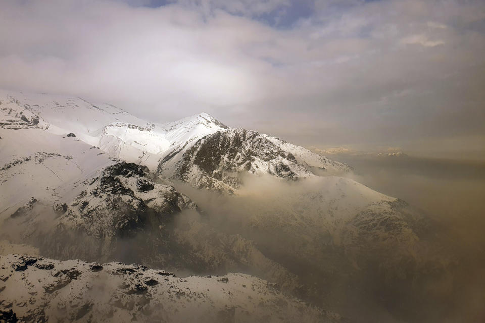 Air pollution blankets a mountain range in Tehran, Iran, Dec 23, 2020. Iran's capital and its major cities have been plunged into darkness as rolling outages in recent weeks left millions with no electricity for hours. With toxic smog blanketing the skies in Tehran and the country buckling under the strain of the pandemic and sanctions targeting Iran’s oil and gas industry, speculation about the spate of blackouts gripped social media. Soon, fingers pointed at an unlikely culprit: Bitcoin. (AP Photo/Ebrahim Noroozi)