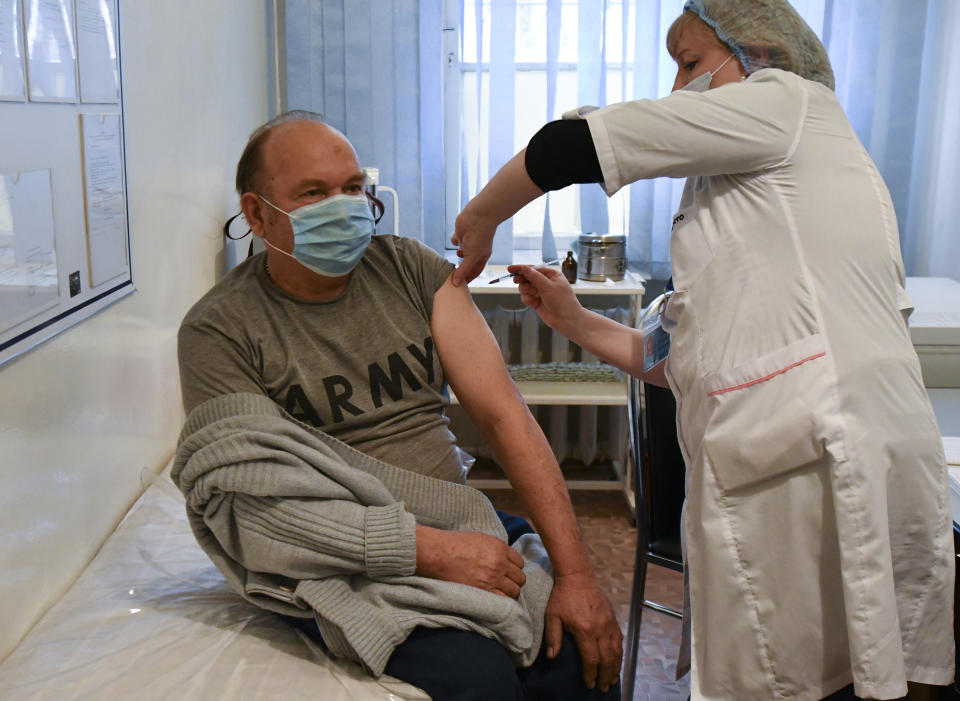 A medical worker administers a shot of China's Sinovac vaccine to a patient in Bishkek, Kyrgyzstan, Monday, March 29, 2021. Vaccinations against COVID-19 started in Kyrgyzstan on Monday with the Chinese SinoPharm vaccine. Medical workers, teachers and law enforcement officials will be the first in line to get the shot. Russian will also provide about 500,000 doses of Russian-made Sputnik V vaccine. (AP Photo/Vladimir Voronin)