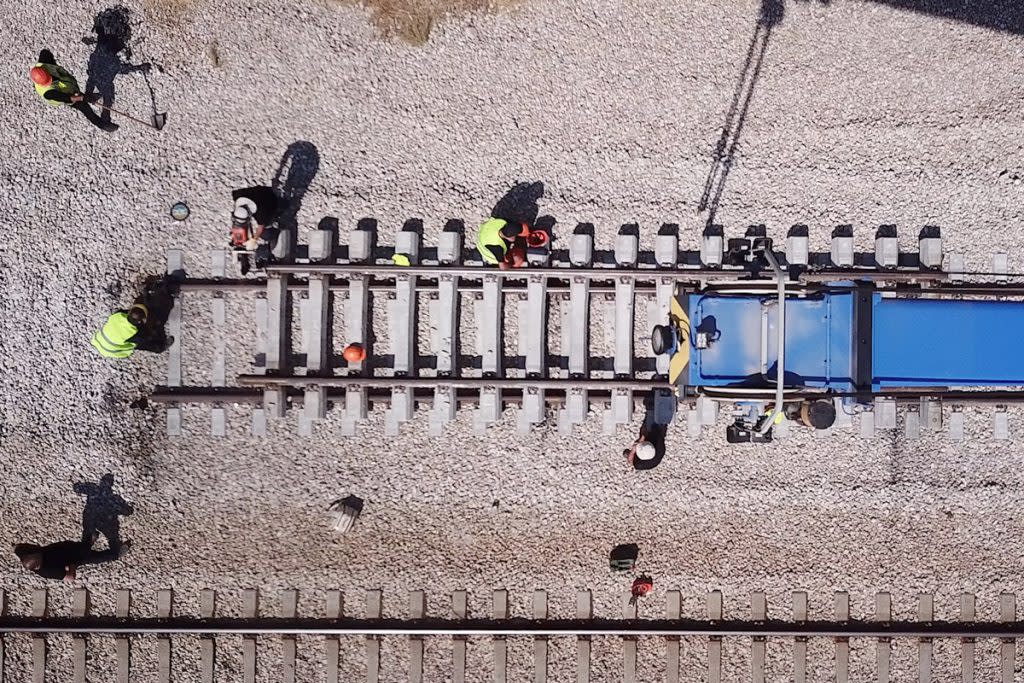 People work on repairing a train track.