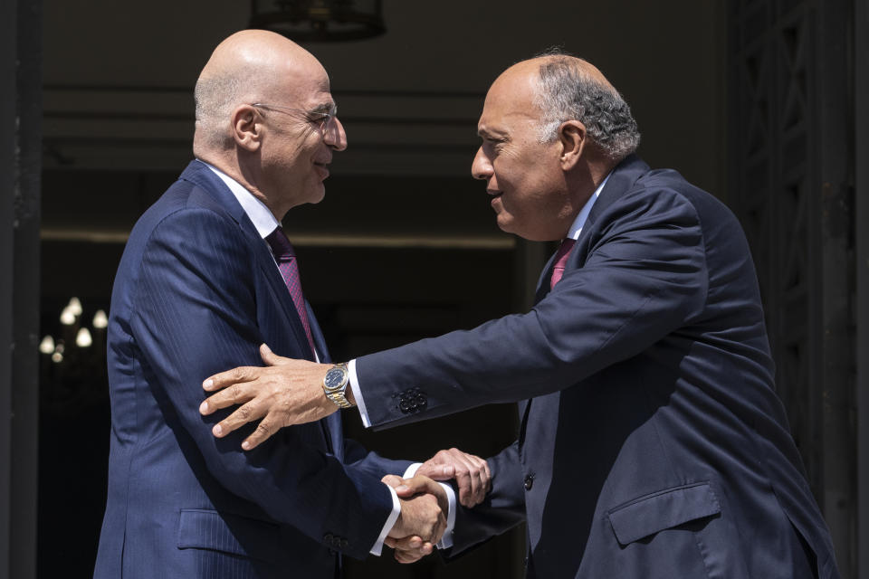 Greek Foreign Minister, Nikos Dendias, left, welcomes his Egyptian counterpart Sameh Shoukry, as they meet in Athens on Tuesday, April 11, 2023. Greece and Egypt have close military ties and are planning to build an undersea electricity grid connector across the Mediterranean. (AP Photo/Petros Giannakouris)