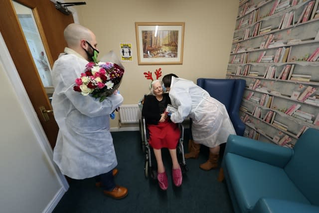 Family hugging loved one in care home on Christmas Day