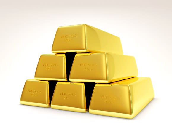 Six gold bars in a pyramid stack.