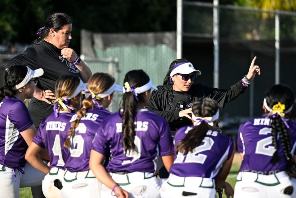 El Diamante's Stephanie Rapozo talks with her team after their win over Redwood in an East Yosemite League high school softball Thursday, April 25, 2024. El Diamante and Redwood hosted a “Purple Out Game” to raise awareness/benefit Crohn’s Disease and Ulcerative Colitis.