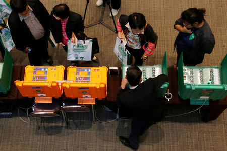 People take a look at Thailand Election Commission's voting machines during an event to kick off the distribution of five million copies of a controversial military-written draft constitution, ahead of the August 7 referendum in Bangkok, Thailand, May 25, 2016. REUTERS/Chaiwat Subprasom