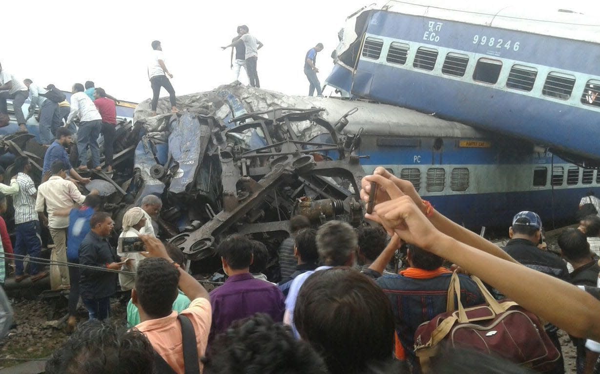 Railway police and local volunteers look for survivors in the upturned coaches of the Kalinga-Utkal Express after an accident near Khatauli, India - AP